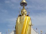 Bangkok 02 01 Luang Pho To Buddha Statue We met a nice man on the way to the Grand Palace, who told us it was closed this morning. Although I had read of this scam, I was feeling great and compassionate and wanted to see how it played out. He mentioned that he could get us a private tuk-tuk tour to show us around some of the Bangkok sights for only a hundred Baht. We took him up on his offer. As long as you are willing to say no to the shopping portion of the tour, it�s great fun indeed. Our first stop was at Luang Pho To, a gigantic 32m x 11m statue of Buddha, built starting in 1867, and covered in 24k golden mosaics. The topknot of the Buddha image supposedly contains a relic of Lord Buddha brought from Sri Lanka.